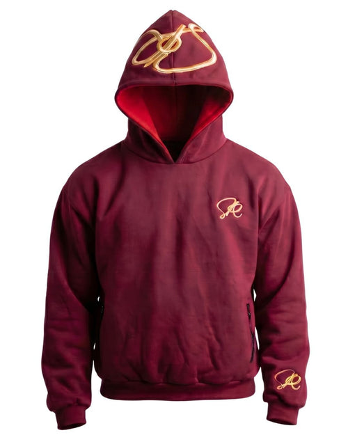 Product shot of crimson side of blaze hoodie with golden embroidered insignia's on the hood, left chest, and left wrist. Including invisible pockets on either side of the waist.