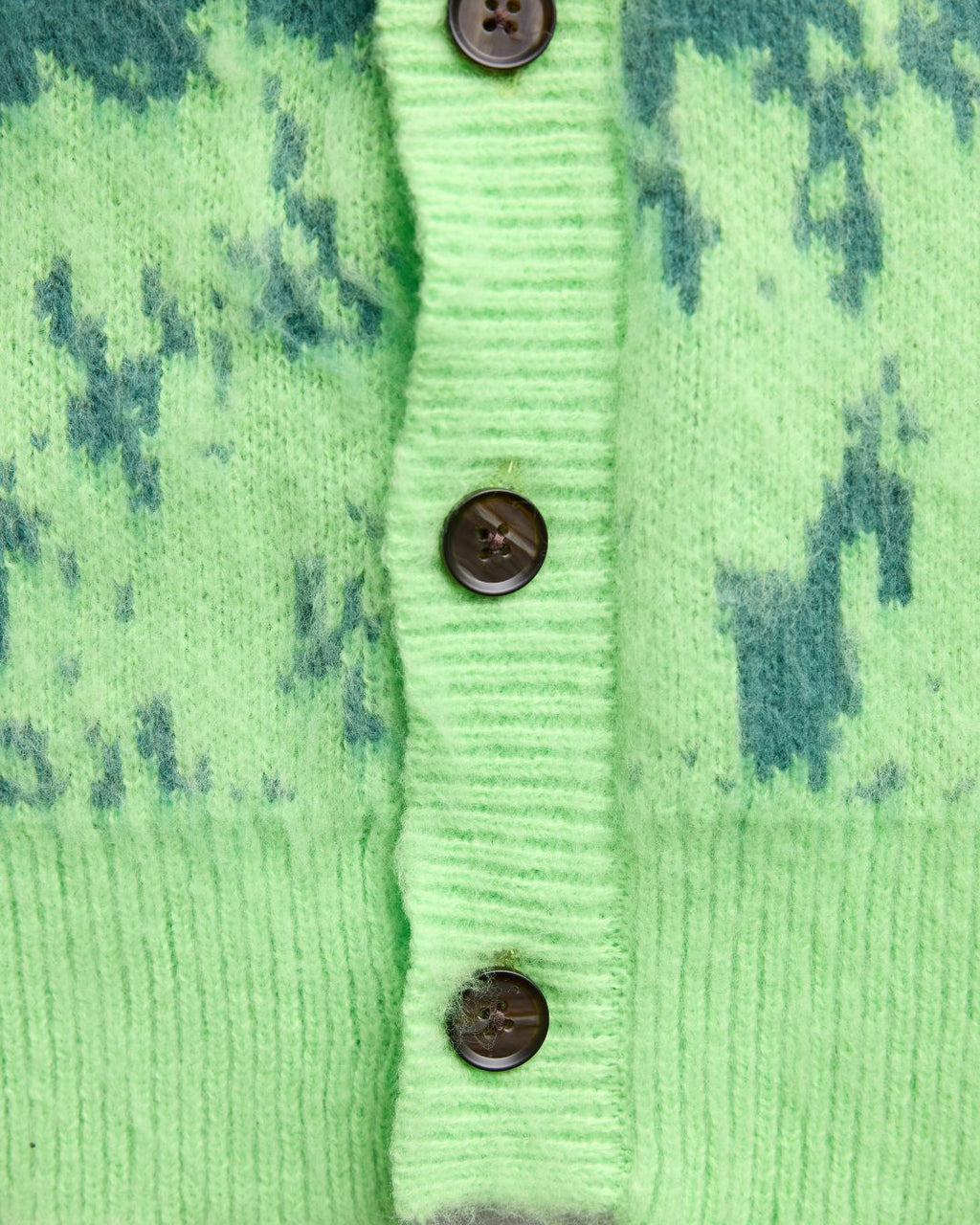 Close-up of the Grass Cardigan’s textured knit fabric showcasing a relaxed fit and vibrant olive green color from a front
