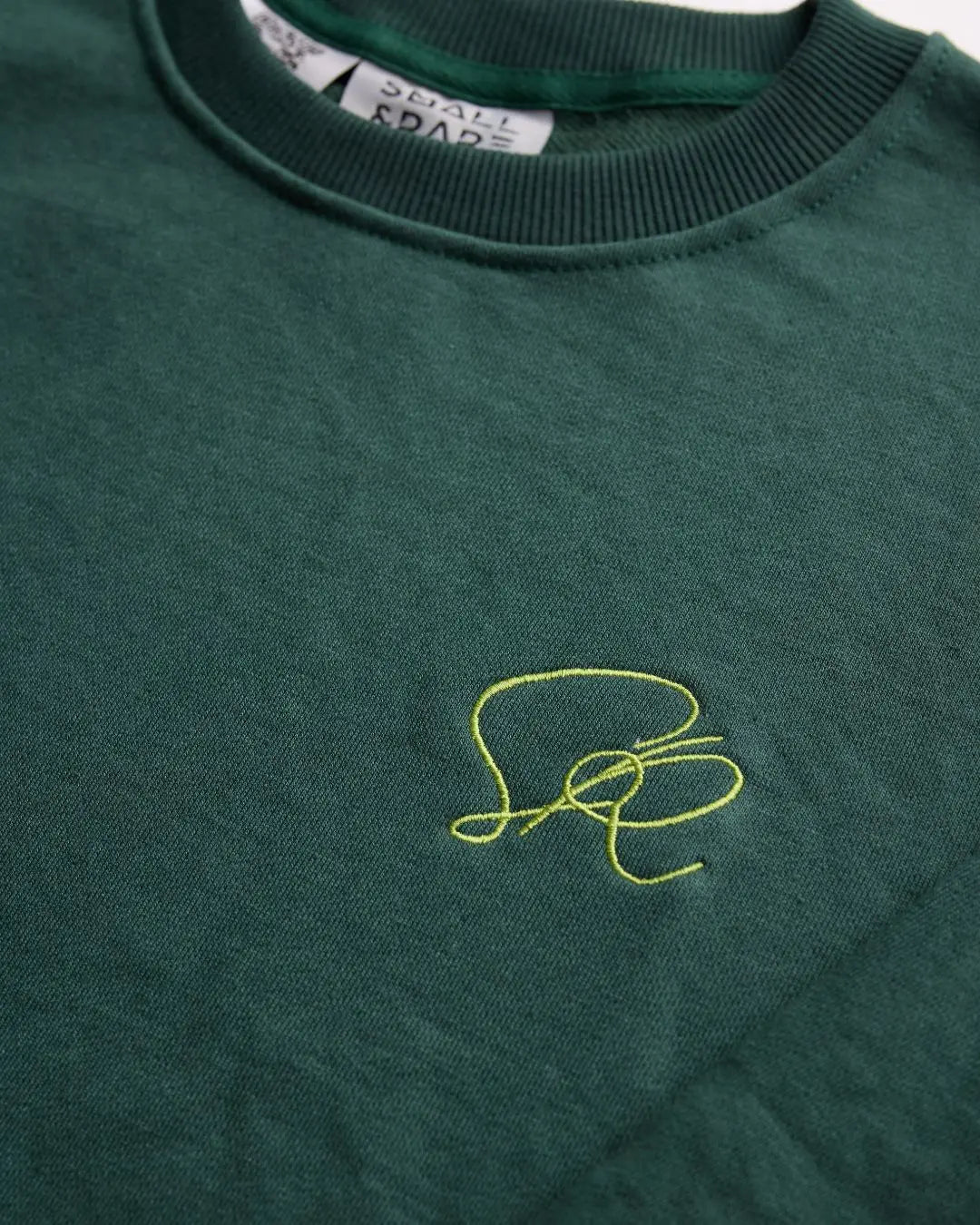 Back detail of the green cotton blend slim-fit streetwear tee highlighting the subtle stitched logo tag at the hem