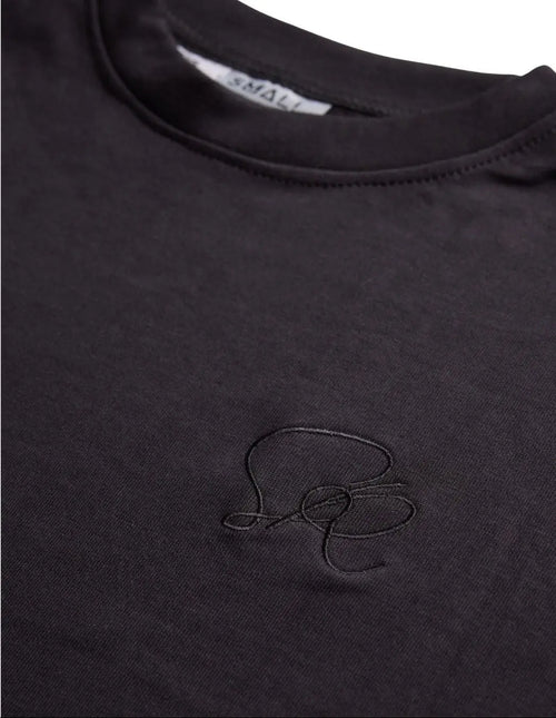 Close-up of the Black Core Streetwear Tee's smooth cotton fabric showing subtle weaving details and slim fit silhouette.