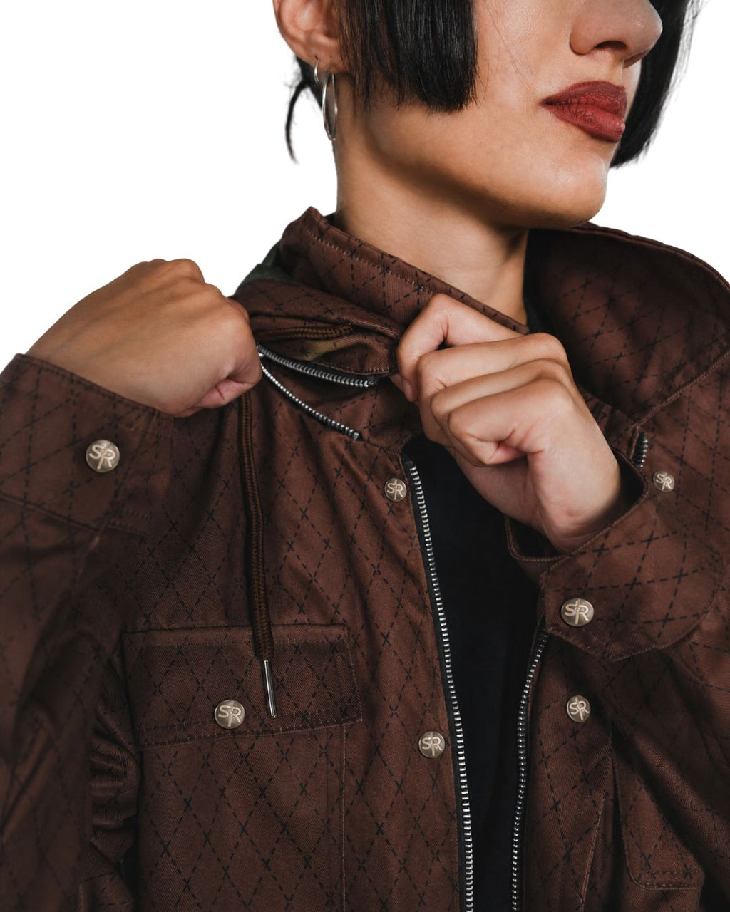 Product shot of woman wearing the Versa Workwear Jacket showcasing zipper function for hood.